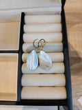 Druppelvormige pasteloorbellen in lichtblauw, wit en zachtroze met ronde metalen creolen