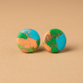 Ronde oorstekers in turquoise, groen en perzik op een beige achtergrond