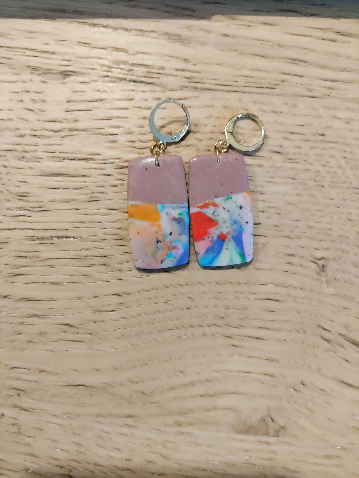 Rechthoekige oorbellen met mauve bovenkant en kleurrijk abstract patroon aan kleine oorringen