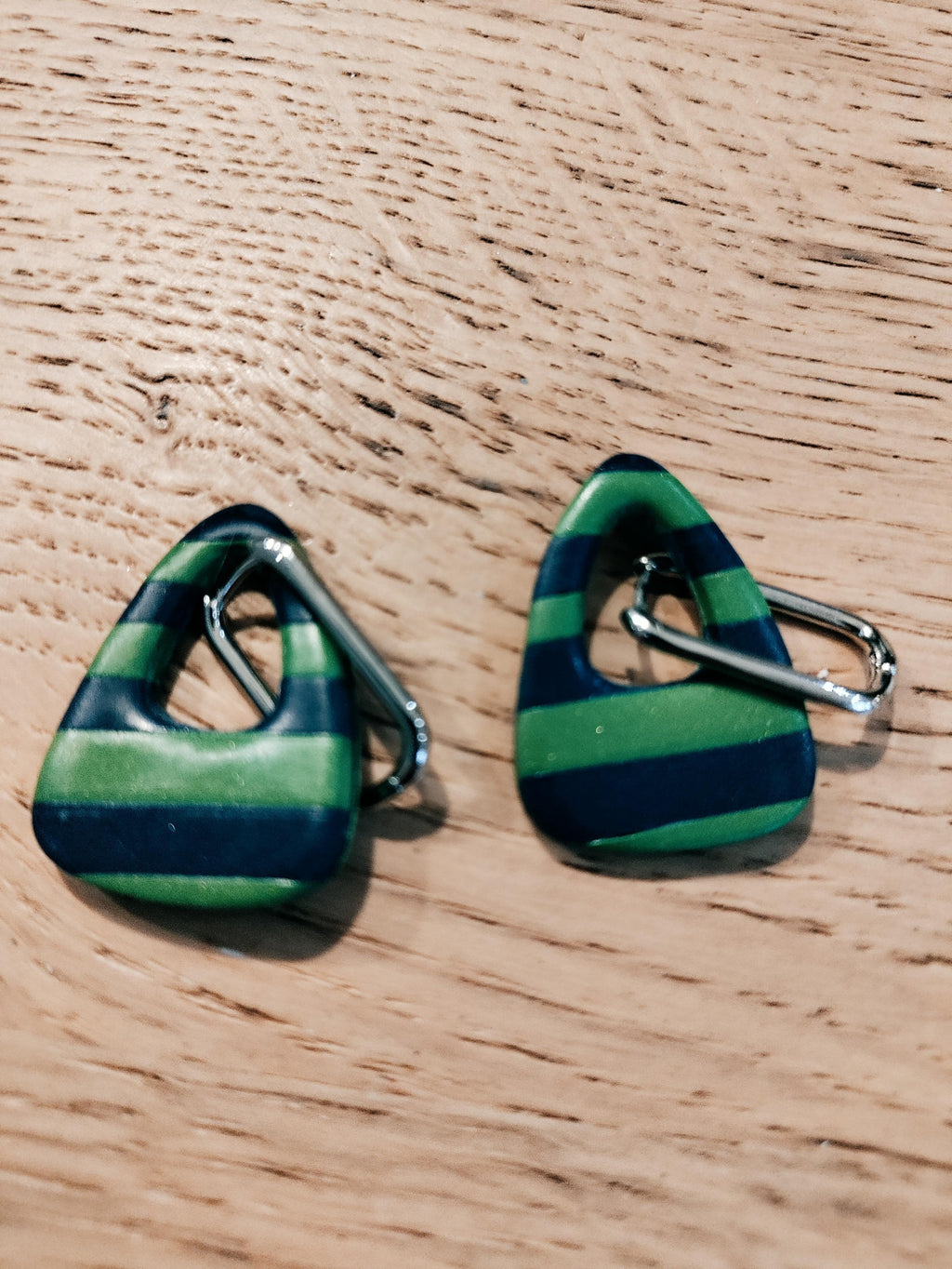 Driehoekige oorbellen met groene en donkerblauwe strepen en zilverkleurige bevestigingen